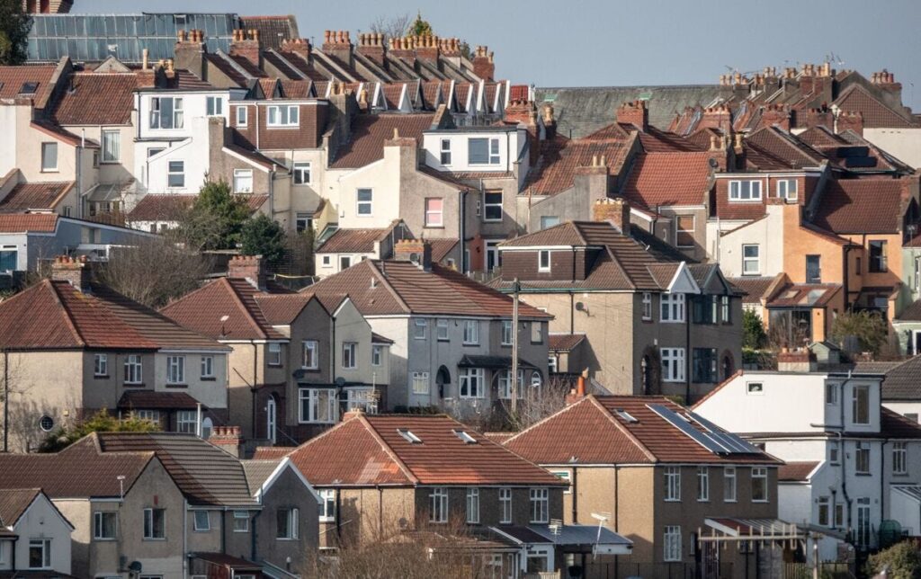 A dense cluster of terraced houses with red-tiled roofs and chimneys, typical of urban residential architecture.
